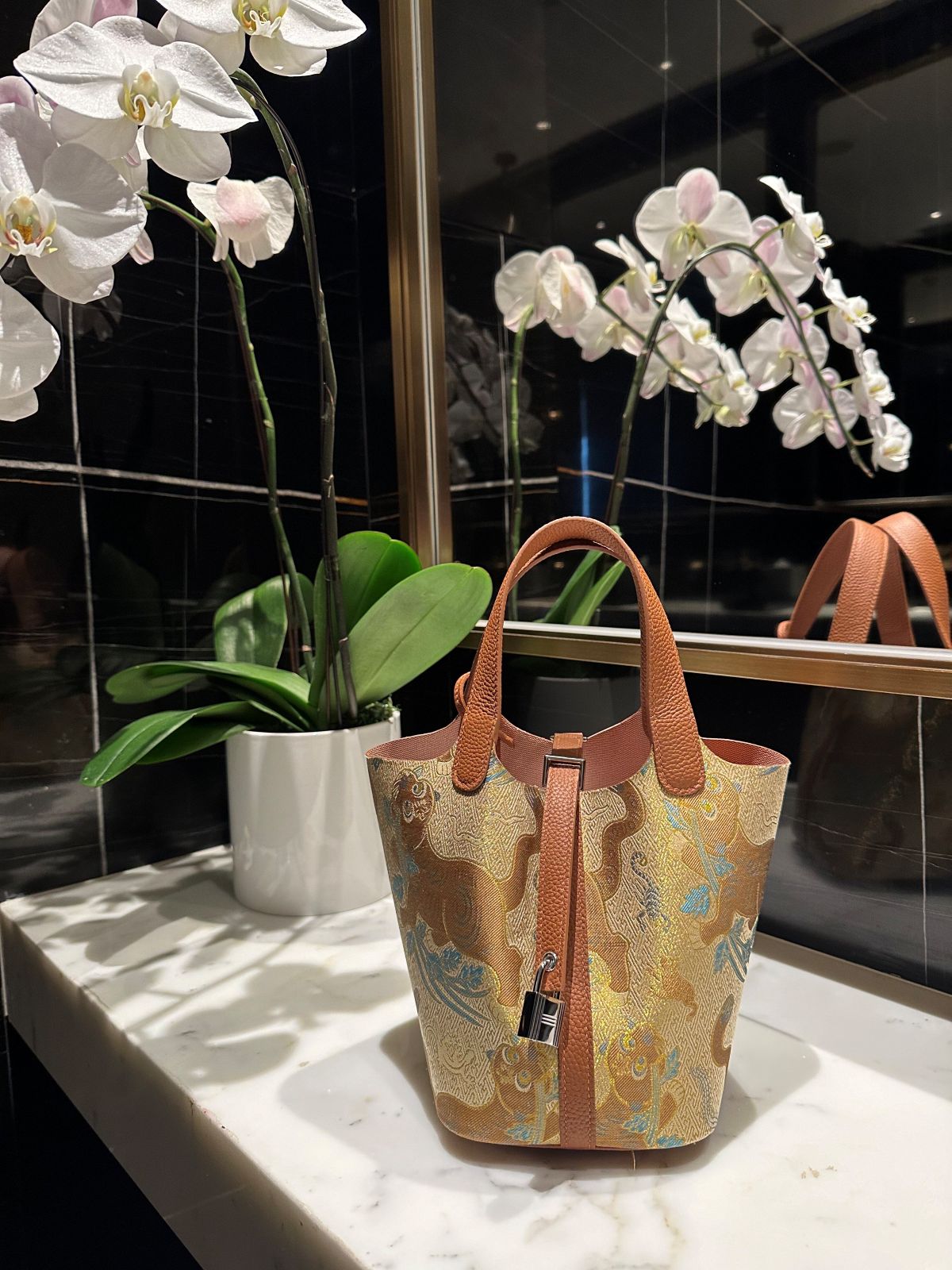 Mulberry silk bucket bag three-quarter view with heritage-inspired motif and refined handbag finish