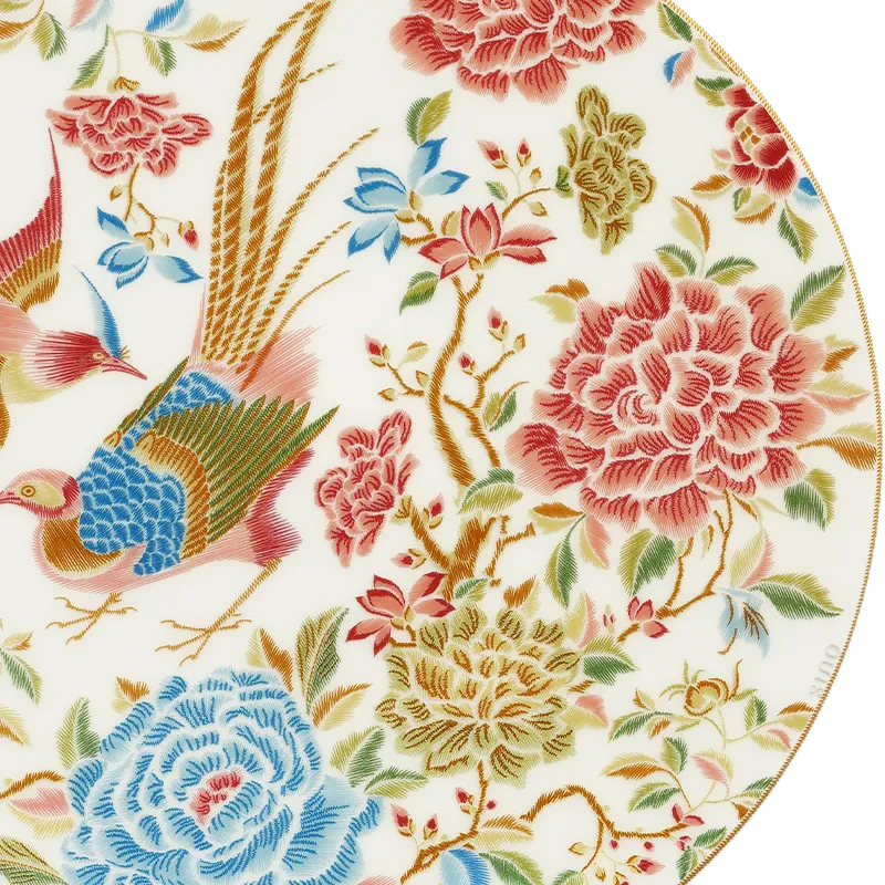 Detailed view of floral and bird design on bone china dinner plate.