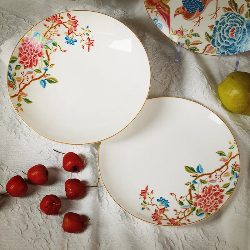 Two Chinoiserie salad plates overlapping on table with hawthorn and pear decoration.