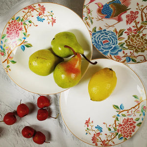 Two overlapping Chinoiserie salad plates with fruits on top plate.