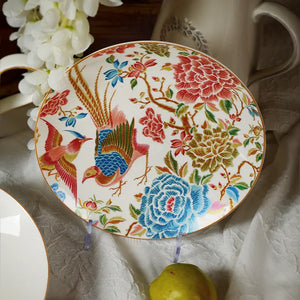 Flat-laid 9’’ round bone china salad plate with white floral decor and a pear.