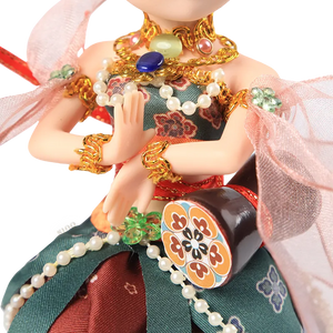 Lower body of 9-inch Dunhuang doll showing red floral skirt and green decorative panels.