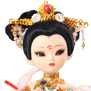 Closeup of 9-inch Dunhuang doll's hand-painted face with red beauty mark and soft, expressive eyes.