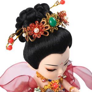 Detail of 9-inch Dunhuang doll's headdress with golden accents, red beads, and green gem.