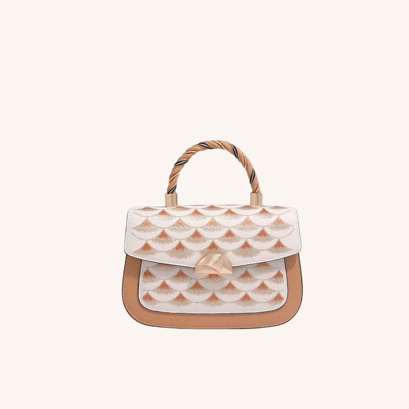 Clutch bag detail with refined gold-tone hardware and heritage embroidery craftsmanship