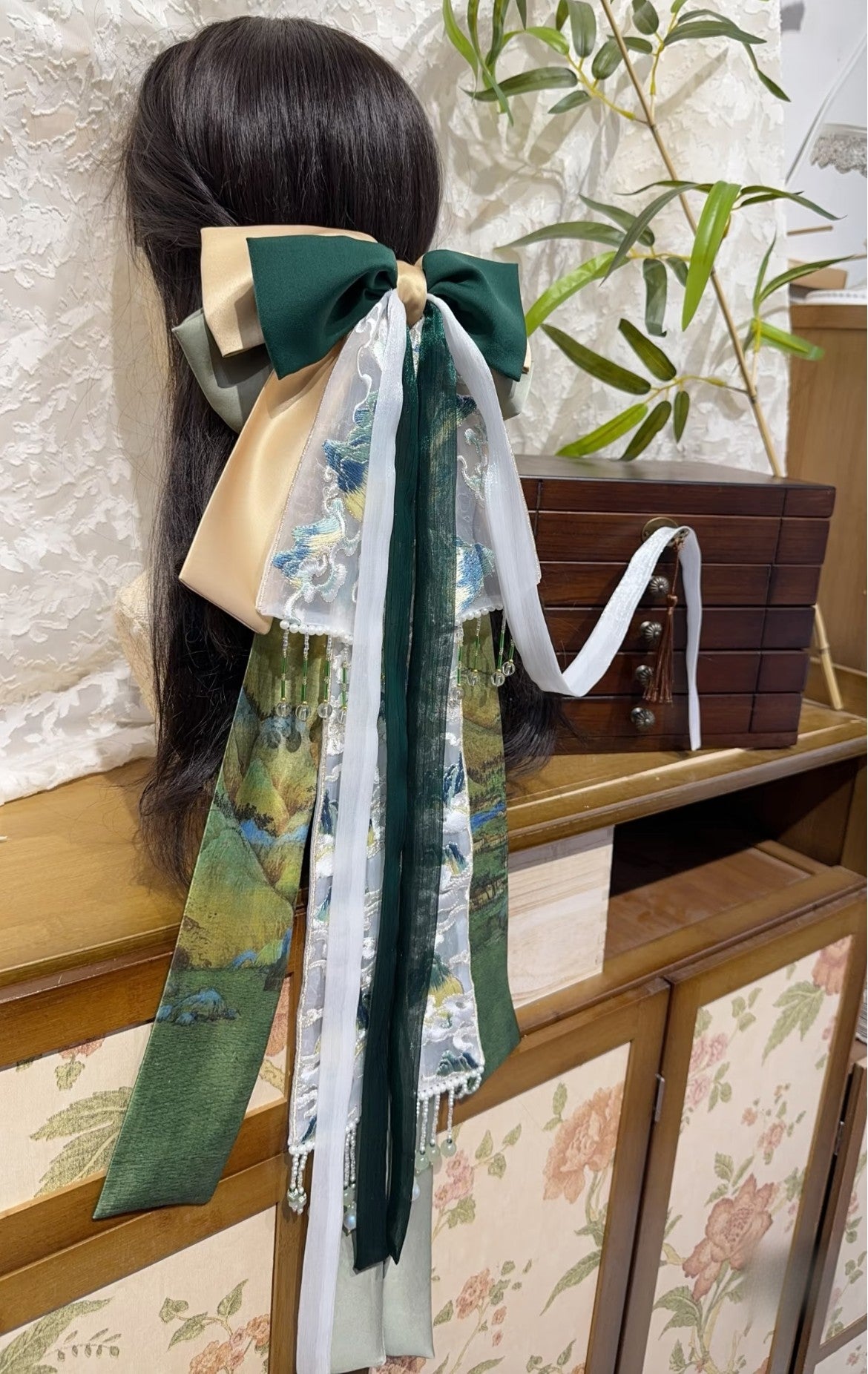 Side view of landscape-inspired new Chinese hair bow with elegant flowing ribbon layers