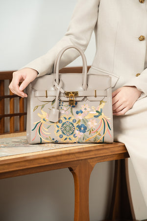 Crossbody bag detail with refined gold-tone hardware and heritage embroidery craftsmanship featuring Phoenix & Pear Blossoms