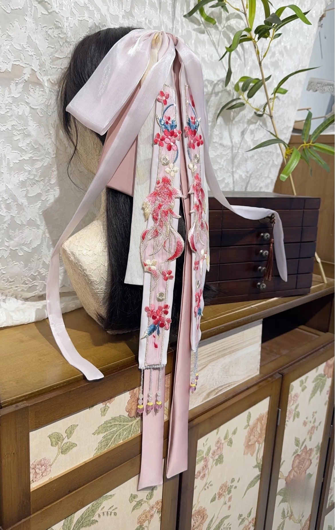 Close view of Pink Koi rabbit-ear bow hair accessory with layered ribbons and delicate beads