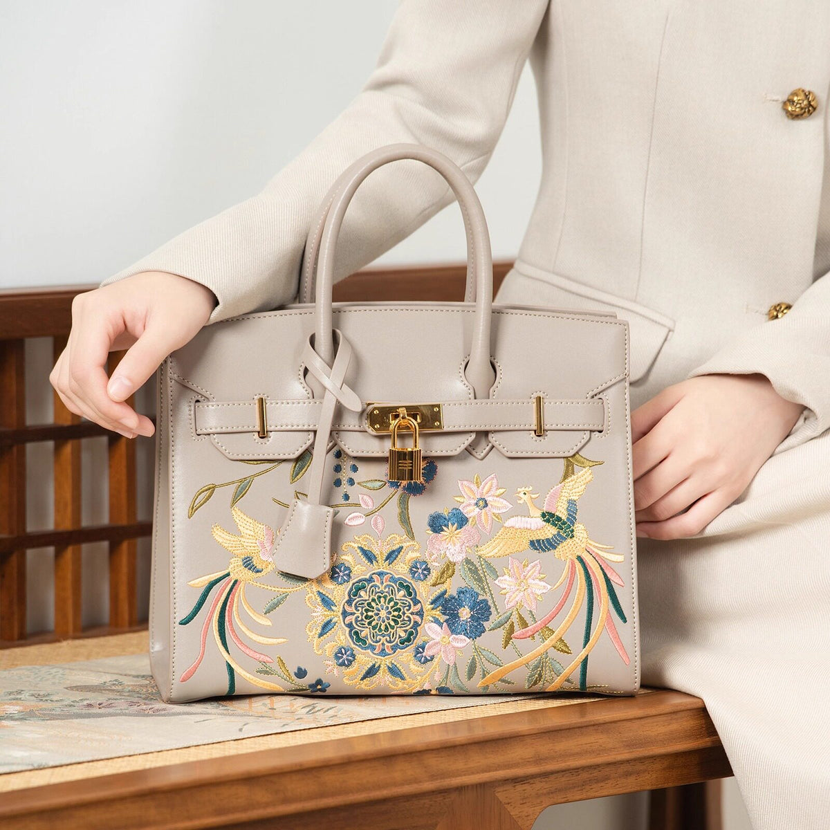 Close view of embroidered crossbody bag showing floral texture and refined leather finish featuring Phoenix & Pear Blossoms