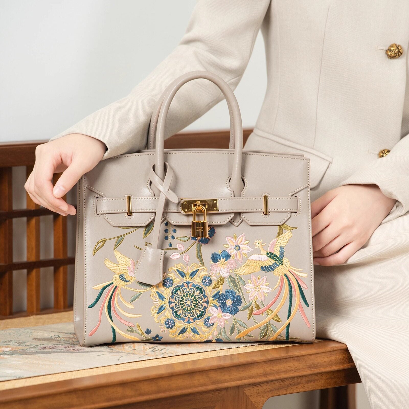 Close view of embroidered crossbody bag showing floral texture and refined leather finish featuring Phoenix & Pear Blossoms