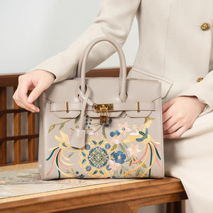 Close view of embroidered crossbody bag showing floral texture and refined leather finish featuring Phoenix & Pear Blossoms