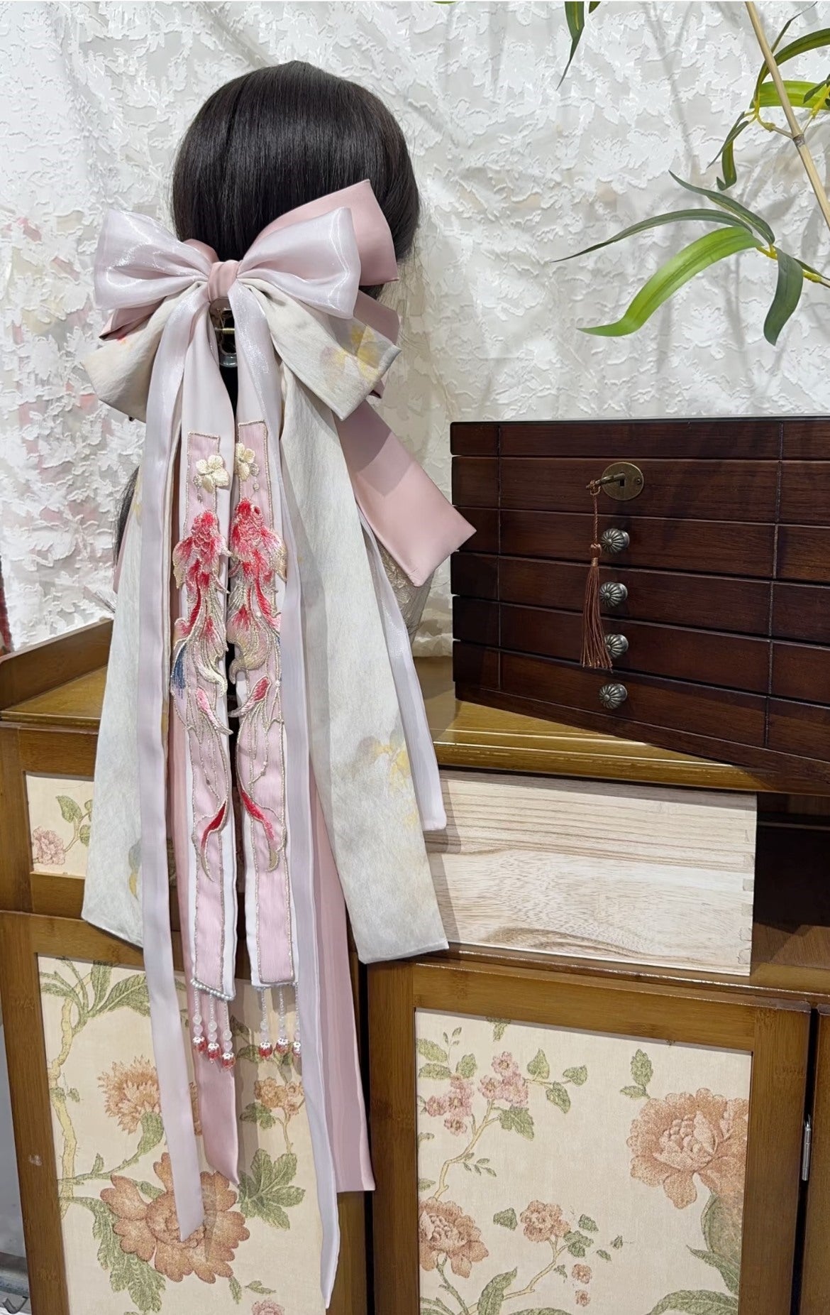 Side view of Pink Koi hair bow accessory showing soft pink layers and back-worn styling