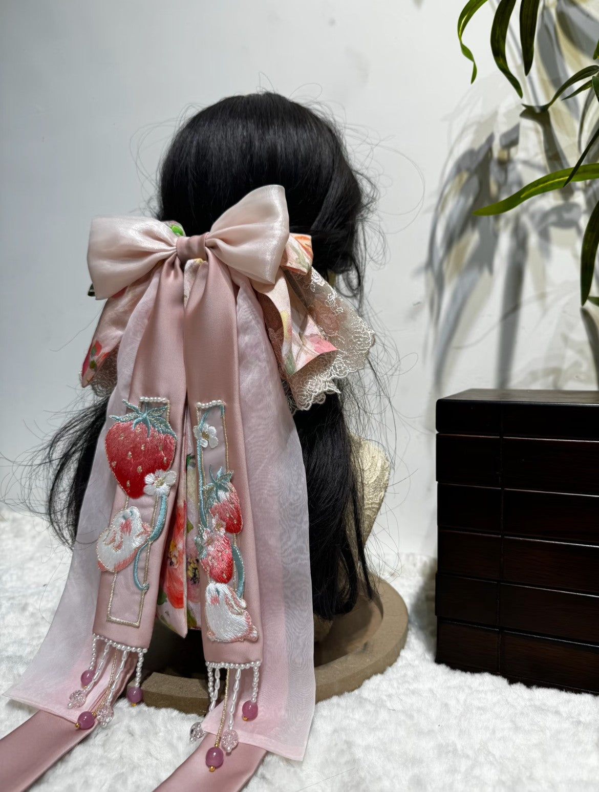 Oversized pink brocade bow hair accessory with lace trim and layered ribbon shape