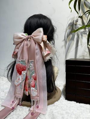 Oversized pink brocade bow hair accessory with lace trim and layered ribbon shape