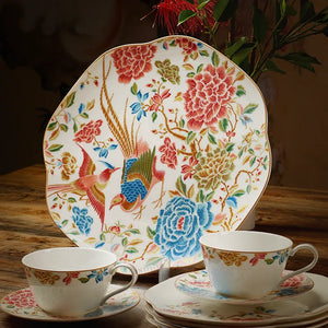 Square dinner plate upright with two cups in front.