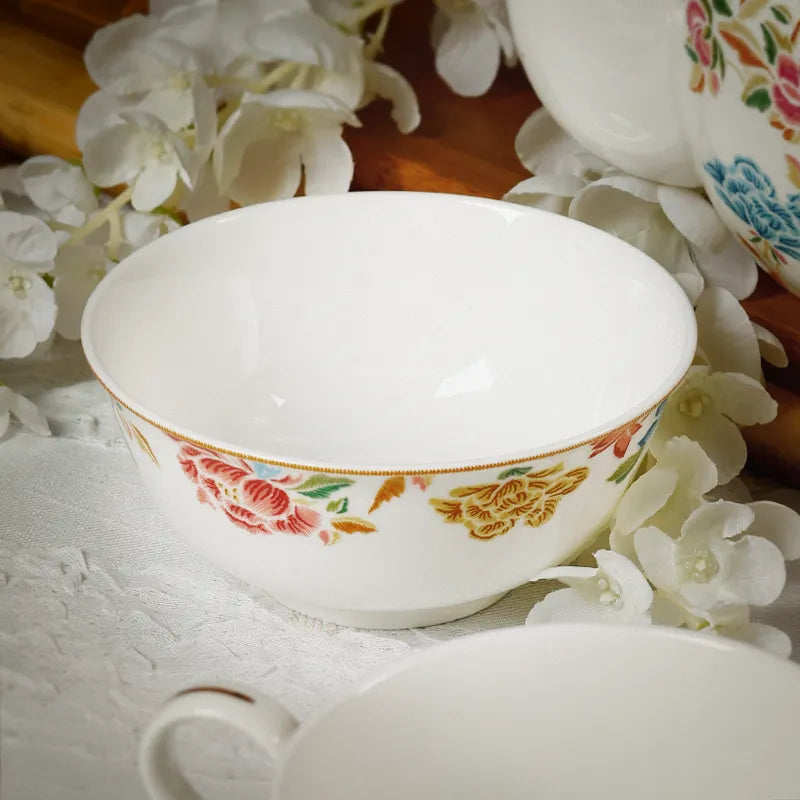 Chinoiserie bone china round bowl on table with floral background (angled view).