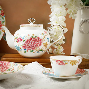 Porcelain teapot, cup and saucer on crisp white linen.