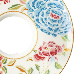 Embossed floral embroidery detail on saucer's right quadrant.