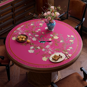 Pink chinoiserie floral bird table mat on round table, top view.