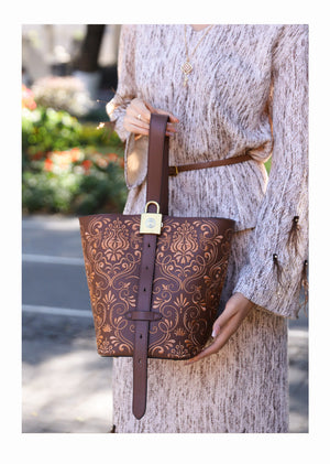 Bucket bag detail with refined gold-tone hardware and heritage embroidery craftsmanship featuring Dunhuang Scroll Grass