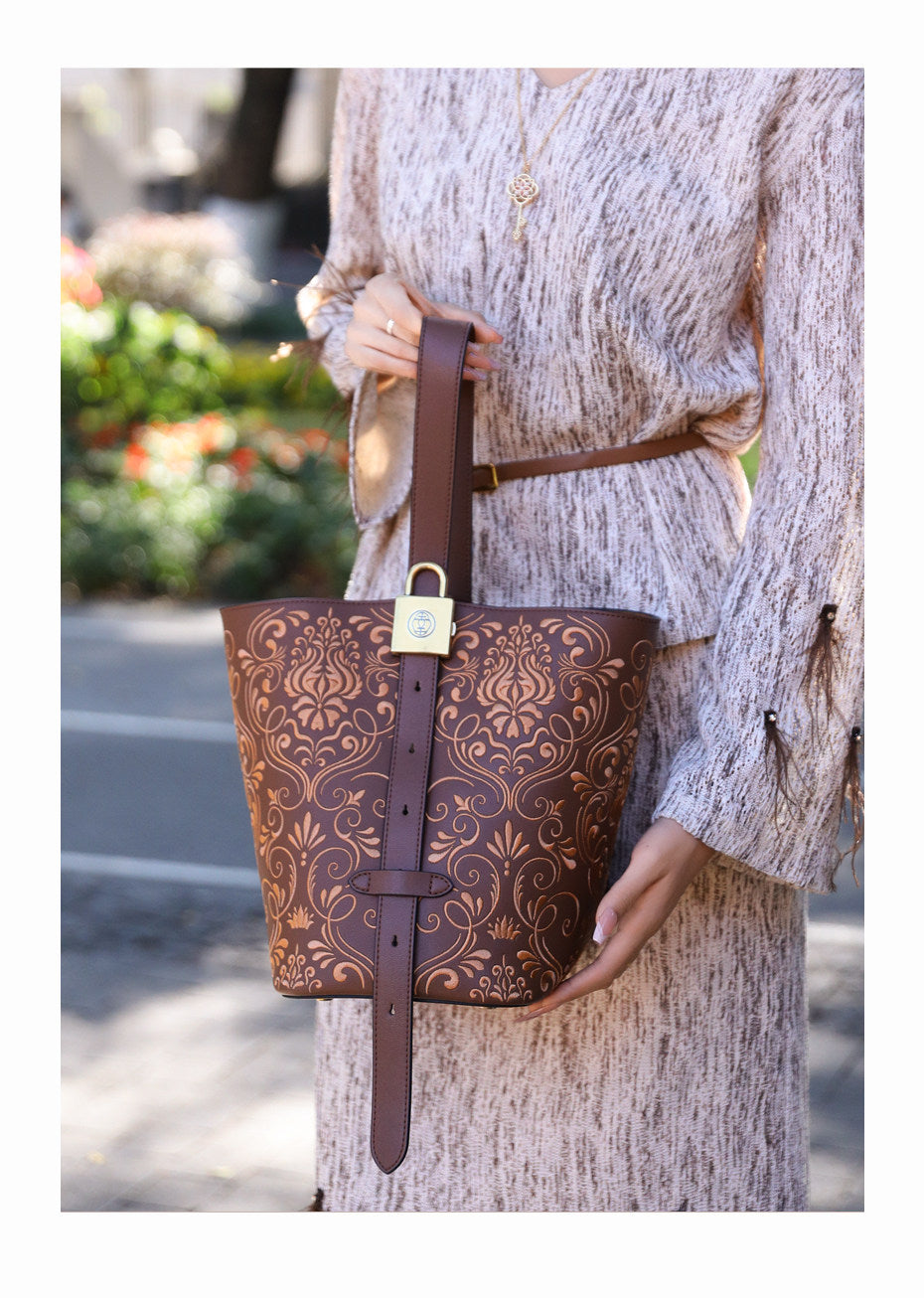 Bucket bag detail with refined gold-tone hardware and heritage embroidery craftsmanship featuring Dunhuang Scroll Grass