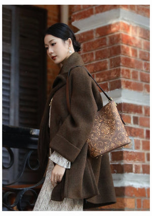 Chinese embroidered bucket bag three-quarter view with heritage-inspired motif and refined handbag finish