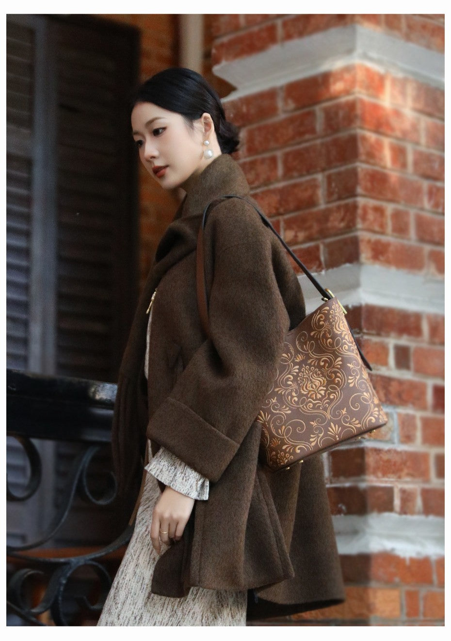 Chinese embroidered bucket bag three-quarter view with heritage-inspired motif and refined handbag finish