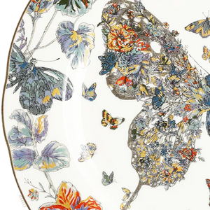 Close-up: Left butterfly wing and floral rim detail on bone china plate.