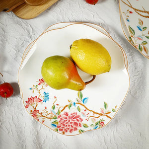 Overhead view of bone china plate with fresh pear on floral design.