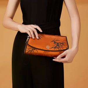 Model in Black Qipao Holding Vintage Brown Bamboo Silk Clutch.