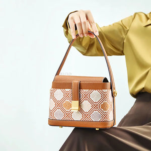 Seated model with brocade bag resting on knees.