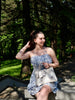 Creator styling a Zhang Guoquan Dream Butterfly Song Brocade handbag outdoors with a blue floral dress in natural sunlight brocademodern