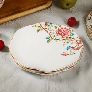 Four 8-inch floral porcelain plates stacked diagonally for elegant storage.
