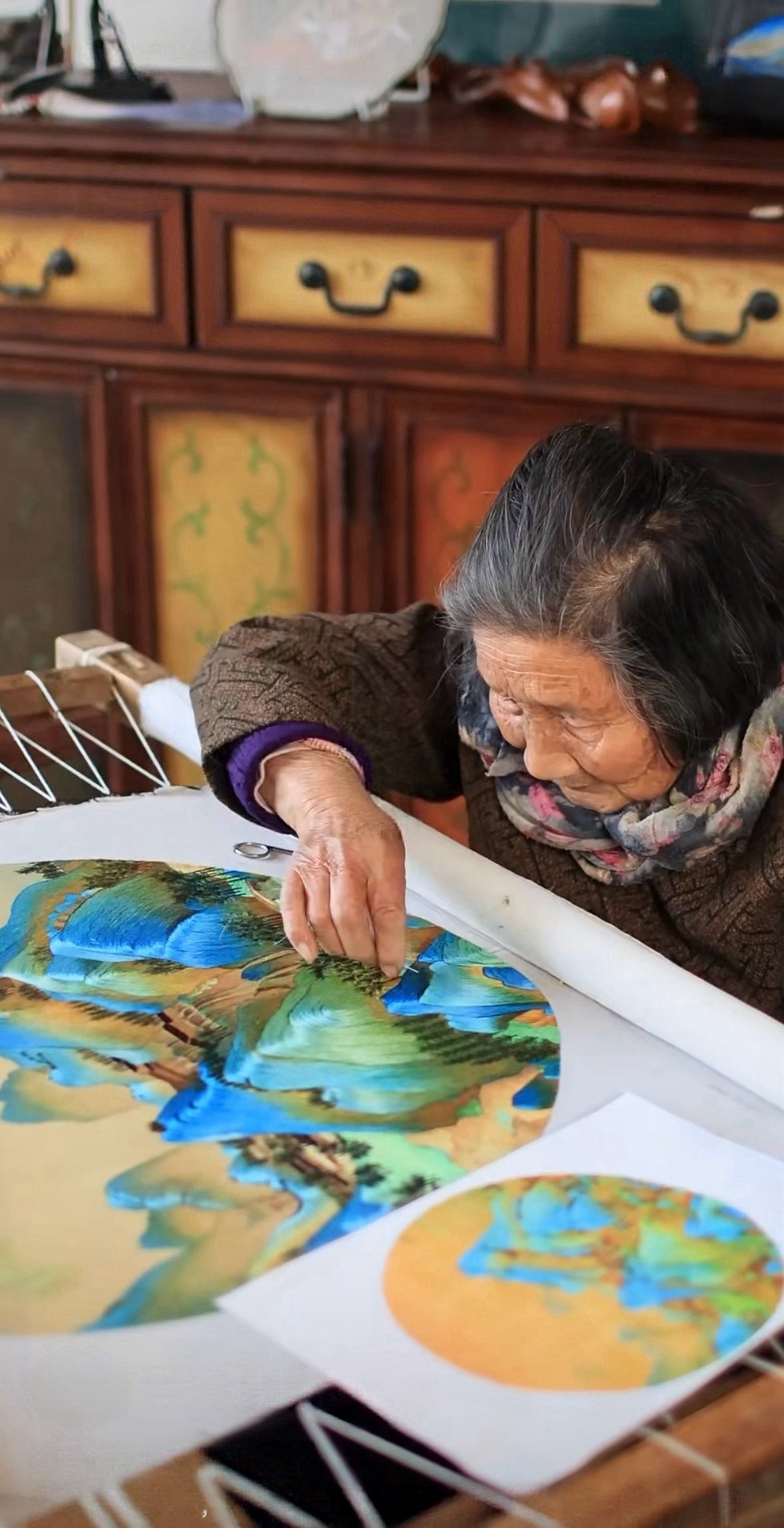 Chinese Su embroidery artisan hand stitching Qianli Jiangshan silk artwork inspired by A Thousand Li of Rivers and Mountains